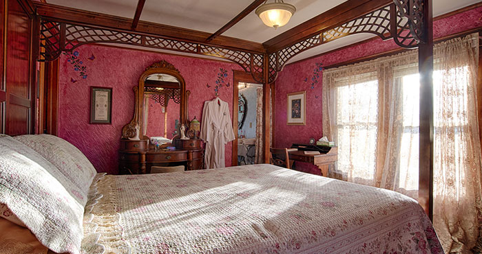 Romantic pink bedroom with four-poster bed.