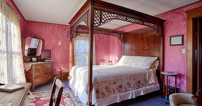 Pink bedroom with four-poster bed.