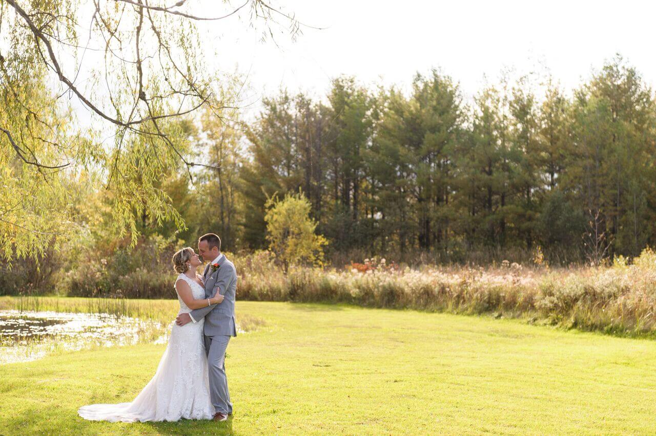 Bride and groom embracing outdoors.