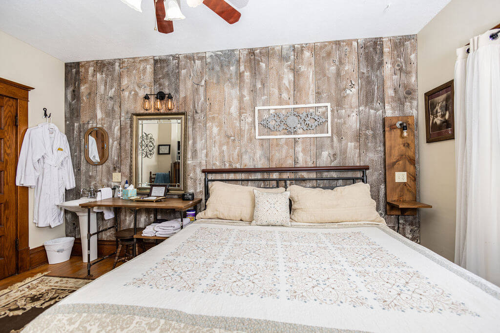 Rustic bedroom with wood wall and bed.